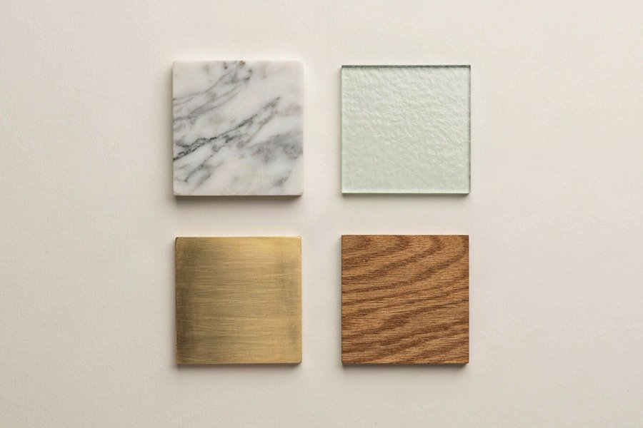 Materialmuster für moderne Couchtische: Marmor, Glas, Messing und Eichenholz im Flatlay